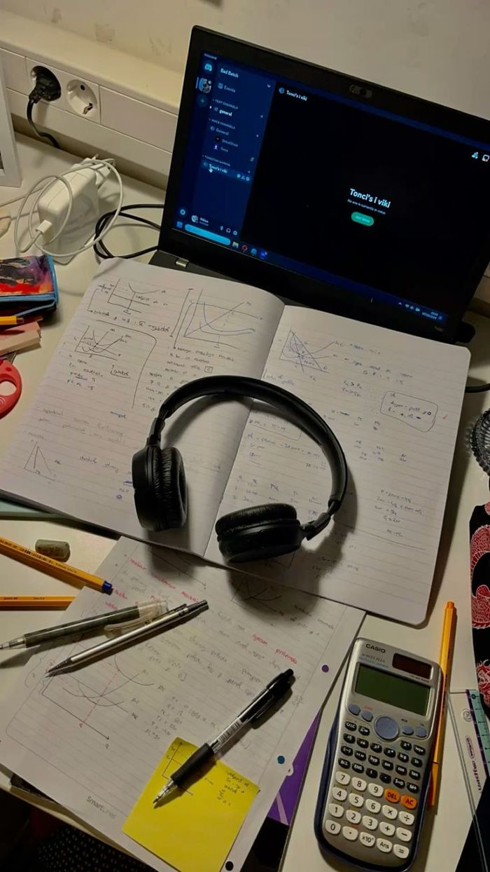 Notebooks, headphones, and a calculator set up for an online math lesson